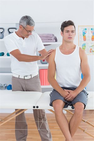 simsearch:400-08018430,k - Doctor examining his patient shoulder in medical office Photographie de stock - Aubaine LD & Abonnement, Code: 400-08018571