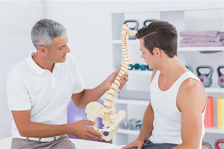 simsearch:400-08018430,k - Doctor showing anatomical spine to his patient in medical office Photographie de stock - Aubaine LD & Abonnement, Code: 400-08018596