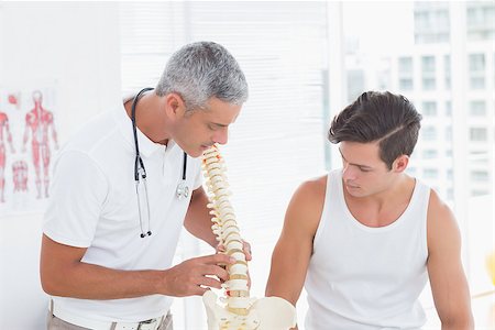 simsearch:400-08018430,k - Doctor showing anatomical spine to his patient in medical office Photographie de stock - Aubaine LD & Abonnement, Code: 400-08018597