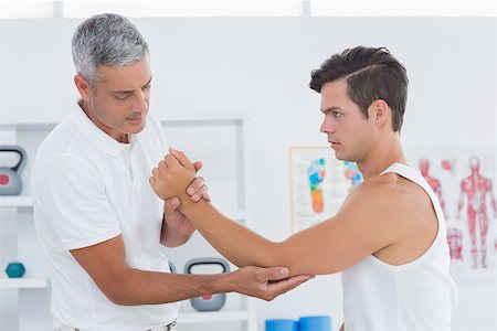 simsearch:400-06690149,k - Doctor examining his patient arm in medical office Stock Photo - Budget Royalty-Free & Subscription, Code: 400-08018604