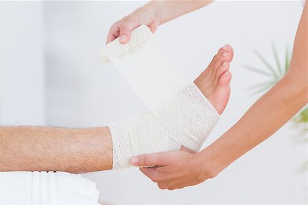 Doctor bandaging her patient ankle in medical office Stock Photo - Budget Royalty-Free & Subscription, Code: 400-08018772