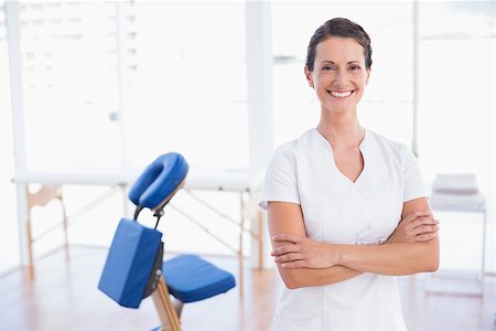 Smiling therapist standing with arms crossed in medical office Stock Photo - Budget Royalty-Free & Subscription, Code: 400-08018917