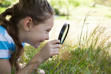 Cute little girl looking through magnifying glass on a sunny day Stock Photo - Budget Royalty-Free & Subscription, Code: 400-08019055
