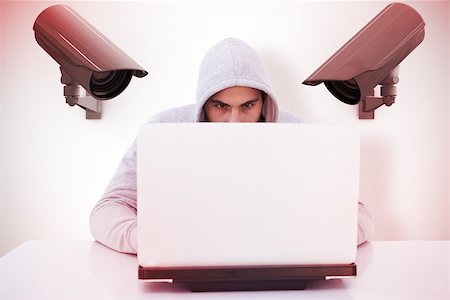 Serious burglar hacking into laptop against cctv camera Photographie de stock - Aubaine LD & Abonnement, Code: 400-08019183