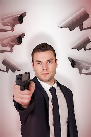 Serious businessman pointing a gun against cctv camera Stock Photo - Budget Royalty-Free & Subscription, Code: 400-08019234