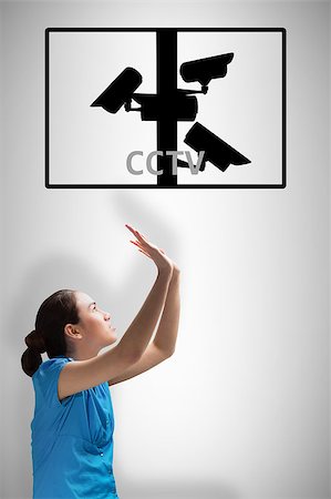Young businesswoman pushing up against cctv Stock Photo - Budget Royalty-Free & Subscription, Code: 400-08019245