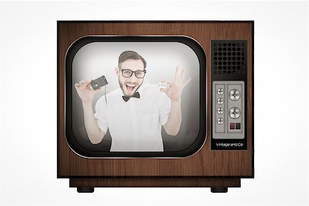 Geeky hipster holding a retro tape cassette player against retro tv Stock Photo - Budget Royalty-Free & Subscription, Code: 400-08019248