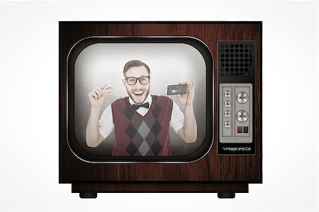 Geeky hipster holding a retro tape cassette player against retro tv Stock Photo - Budget Royalty-Free & Subscription, Code: 400-08019249