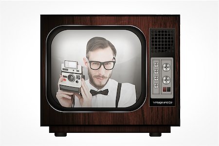 Geeky hipster holding a retro camera against retro tv Stock Photo - Budget Royalty-Free & Subscription, Code: 400-08019252