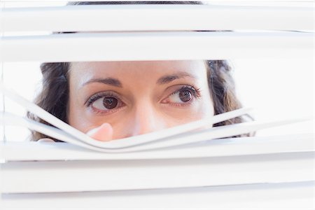 Curious woman looking through blinds in the house Stock Photo - Budget Royalty-Free & Subscription, Code: 400-08019459