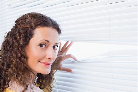 Curious woman looking through blinds in the house Stock Photo - Budget Royalty-Free & Subscription, Code: 400-08019464