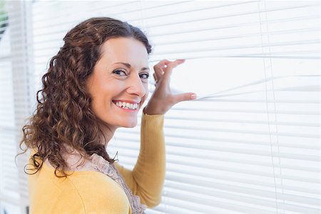 Curious woman looking through blinds in the house Stock Photo - Budget Royalty-Free & Subscription, Code: 400-08019465