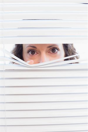 Curious woman looking through blinds in the house Stock Photo - Budget Royalty-Free & Subscription, Code: 400-08019460