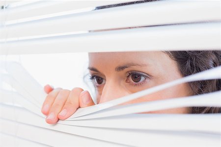 Curious woman looking through blinds in the house Stock Photo - Budget Royalty-Free & Subscription, Code: 400-08019461