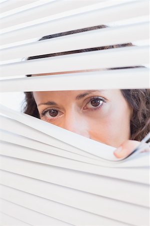simsearch:400-07266908,k - Curious woman looking through blinds in the house Photographie de stock - Aubaine LD & Abonnement, Code: 400-08019462