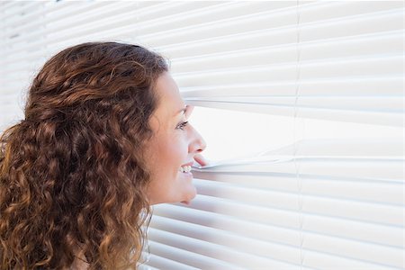 Curious woman looking through blinds in the house Stock Photo - Budget Royalty-Free & Subscription, Code: 400-08019463