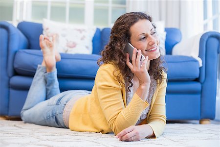 simsearch:400-07931092,k - Pretty brunette lying on the floor and speaking on the phone in the living room Foto de stock - Super Valor sin royalties y Suscripción, Código: 400-08019476