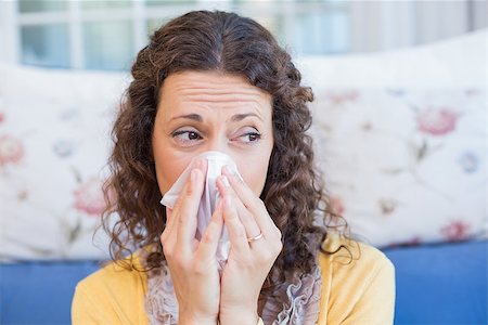 simsearch:400-06801081,k - Sick woman blowing her nose in the living room Photographie de stock - Aubaine LD & Abonnement, Code: 400-08019479