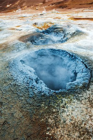 Mudpot in the geothermal area Hverir, Iceland. The area around the boiling mud is multicolored and cracked. Fotografie stock - Microstock e Abbonamento, Codice: 400-08012971