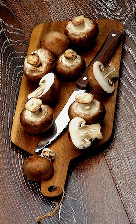 simsearch:400-08011809,k - Gourmet Raw Portabello Mushrooms Full Body and Halves with Table Knife on Cutting Board closeup on Dark Wooden background Photographie de stock - Aubaine LD & Abonnement, Code: 400-08013361