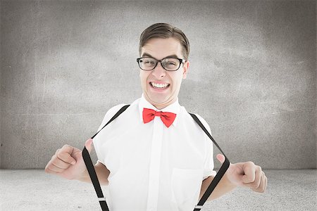 simsearch:400-08020381,k - Geeky hipster pulling his suspenders against grey room Fotografie stock - Microstock e Abbonamento, Codice: 400-08020386