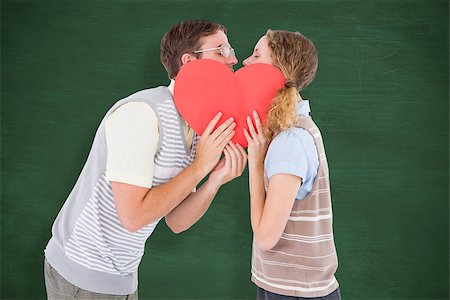 simsearch:400-08380794,k - Geeky hipster couple kissing behind heart card against green chalkboard Stockbilder - Microstock & Abonnement, Bildnummer: 400-08020434