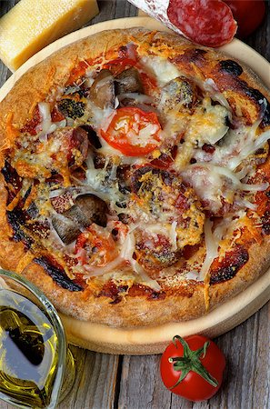 simsearch:6126-08635695,k - Homemade Pizza with Edible Mushrooms, Tomatoes, Salami and Grated Cheese on Circle Cutting Board and Ingredients on Wooden background. Top View Foto de stock - Super Valor sin royalties y Suscripción, Código: 400-08020667