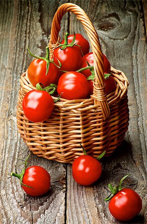 simsearch:400-06485810,k - Heap of Perfect Ripe Cherry Tomatoes with Stems in Wicker Basket isolated on Rustic Wooden background Fotografie stock - Microstock e Abbonamento, Codice: 400-08020787