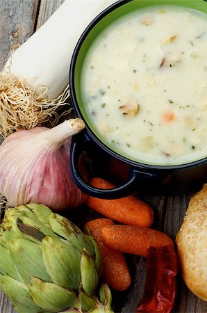 simsearch:400-07625359,k - Healthy Artichoke Creamy Soup with Leek, Carrot, Garlic and Cheese in Dark Blue Pannikin closeup on Rustic Wooden background. Top View Photographie de stock - Aubaine LD & Abonnement, Code: 400-08021179