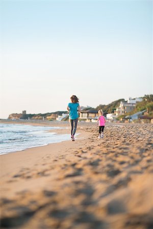 pictures of girls at beach rear - Healthy mother and baby girl running on beach in the evening. rear view Stock Photo - Budget Royalty-Free & Subscription, Code: 400-08021546