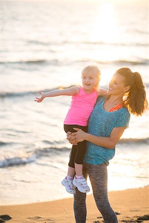 simsearch:400-08864986,k - Healthy mother and baby girl pointing while on beach in the evening Stock Photo - Budget Royalty-Free & Subscription, Code: 400-08021554