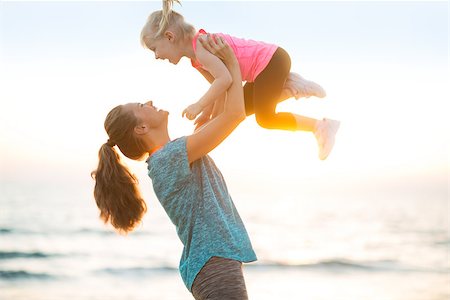 simsearch:400-06867373,k - Mother throwing baby up on beach in the evening Stockbilder - Microstock & Abonnement, Bildnummer: 400-08021566