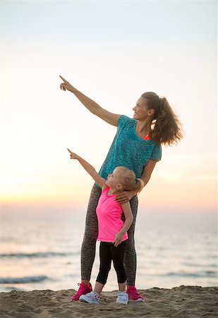 simsearch:400-06867373,k - Healthy mother and baby girl on beach in the evening pointing Stockbilder - Microstock & Abonnement, Bildnummer: 400-08021579