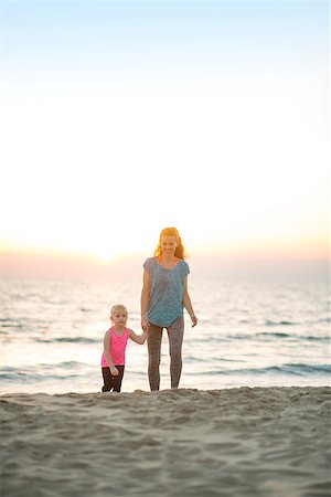 simsearch:400-06867373,k - Healthy mother and baby girl walking on beach in the evening Stockbilder - Microstock & Abonnement, Bildnummer: 400-08021571