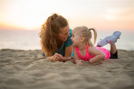 simsearch:400-06867373,k - Happy mother and baby girl laying on beach in the evening Stockbilder - Microstock & Abonnement, Bildnummer: 400-08021582