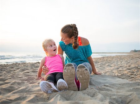 Portrait of fitness mother and surprised baby girl sitting on beach Stock Photo - Budget Royalty-Free & Subscription, Code: 400-08021636