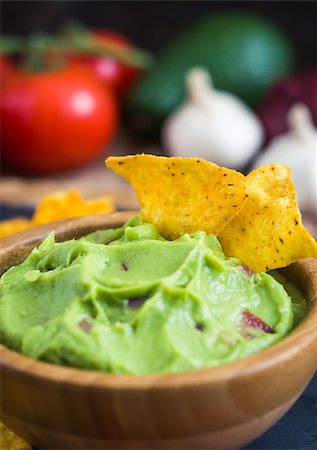 simsearch:400-08052263,k - Guacamole in Wooden Bowl with Tortilla Chips and Ingredients Close Up Photographie de stock - Aubaine LD & Abonnement, Code: 400-08022516