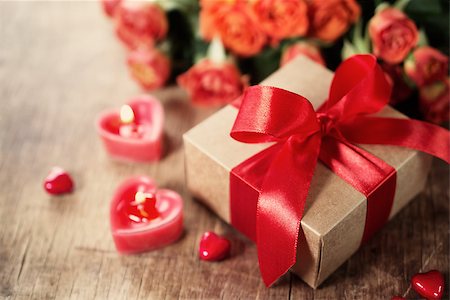 simsearch:400-08034170,k - Gift with red bow and heart-shaped candles on the wooden background, Valentines Photographie de stock - Aubaine LD & Abonnement, Code: 400-08034175