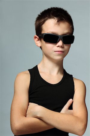 simsearch:400-08036451,k - Cool boy in sunglasses with crossed hands on grey background Stock Photo - Budget Royalty-Free & Subscription, Code: 400-08034278