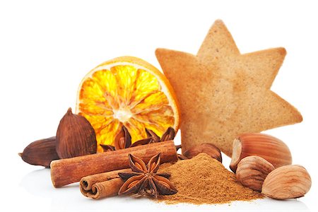 simsearch:400-04145237,k - Culinary aromatic spices christmas background. Anise, cinnamon and various nuts. Star shaped gingerbread cookie and orange slice in background on white. Traditional xmas still life. Foto de stock - Royalty-Free Super Valor e Assinatura, Número: 400-08034407