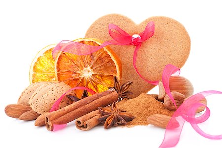 simsearch:400-04145237,k - Natural traditional christmas background with orange, almond, various nuts and spices decorated with pink ribbon isolated on white background. Traditional natural festive food. Foto de stock - Royalty-Free Super Valor e Assinatura, Número: 400-08034411