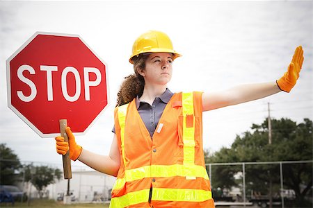 simsearch:400-04485428,k - Female construction apprentice holding a stop sign and directing traffic. Foto de stock - Super Valor sin royalties y Suscripción, Código: 400-08034918