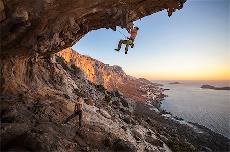 simsearch:400-08072896,k - Male rock climber climbing on a roof in a cave, his partner belaying Foto de stock - Royalty-Free Super Valor e Assinatura, Número: 400-08035129