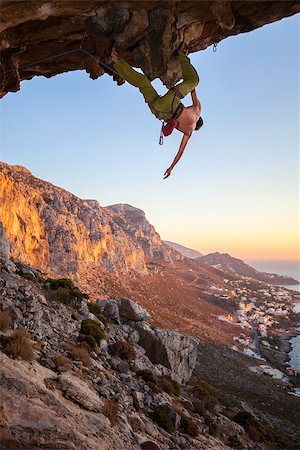 simsearch:400-07292725,k - Male climber on overhanging rock against beautiful view of coast below Photographie de stock - Aubaine LD & Abonnement, Code: 400-08035145