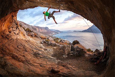 simsearch:400-07292725,k - Male rock climber climbing along a roof in a cave at sunset Photographie de stock - Aubaine LD & Abonnement, Code: 400-08035459