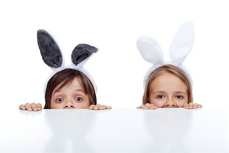 simsearch:400-07254895,k - Kids with bunny ears peeking from beneath the table - waiting for the easter rabbit Stock Photo - Budget Royalty-Free & Subscription, Code: 400-08036296