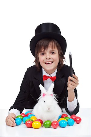Young magician boy preparing for easter - conjuring a white rabbit and colorful eggs Foto de stock - Super Valor sin royalties y Suscripción, Código: 400-08036300