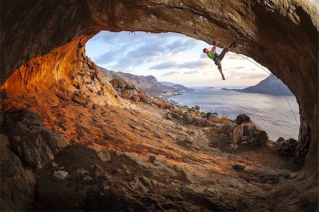 simsearch:400-08072896,k - Male rock climber climbing along a roof in a cave at sunset Foto de stock - Royalty-Free Super Valor e Assinatura, Número: 400-08036336