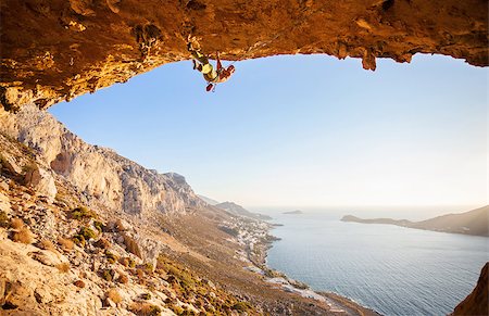 simsearch:400-07292725,k - Male rock climber climbing along a roof in a cave at sunset Photographie de stock - Aubaine LD & Abonnement, Code: 400-08036331