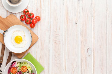 Healthy breakfast with fried egg, tomatoes and salad on white wooden table with copy space Stock Photo - Budget Royalty-Free & Subscription, Code: 400-08037265
